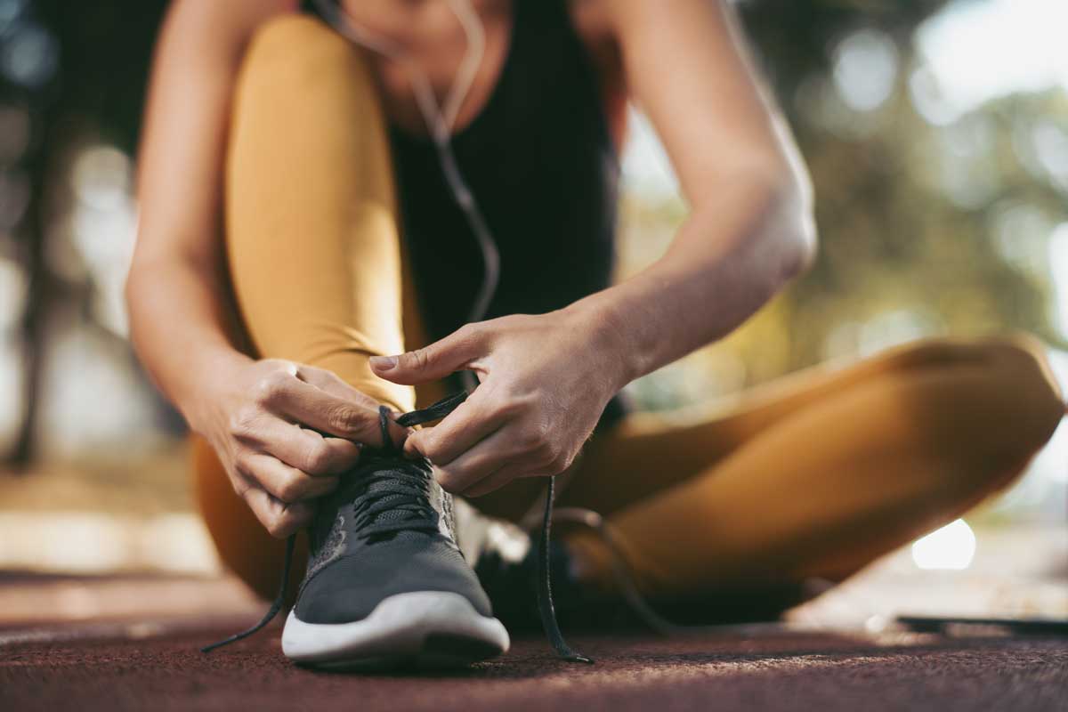 fitness woman sitting tying her shoelace