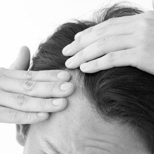 Greyscale photo of man parting hair