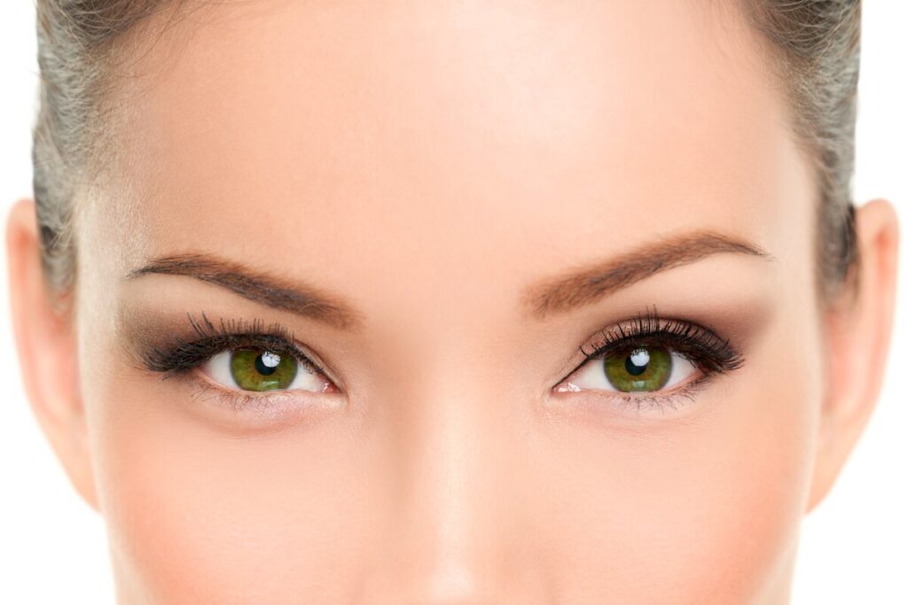 close up of a beautiful woman’s green eyes and forehead