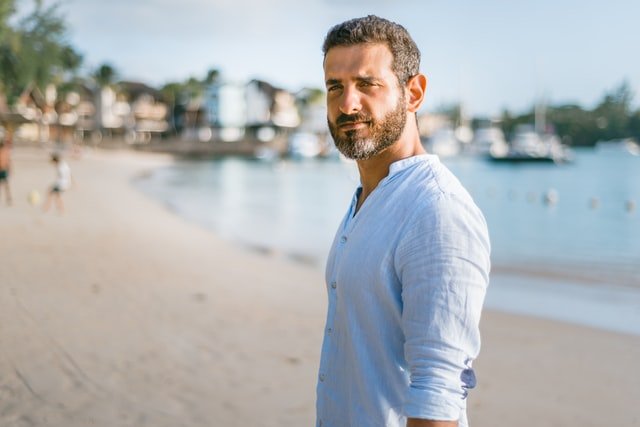 A man on the beach wearing white