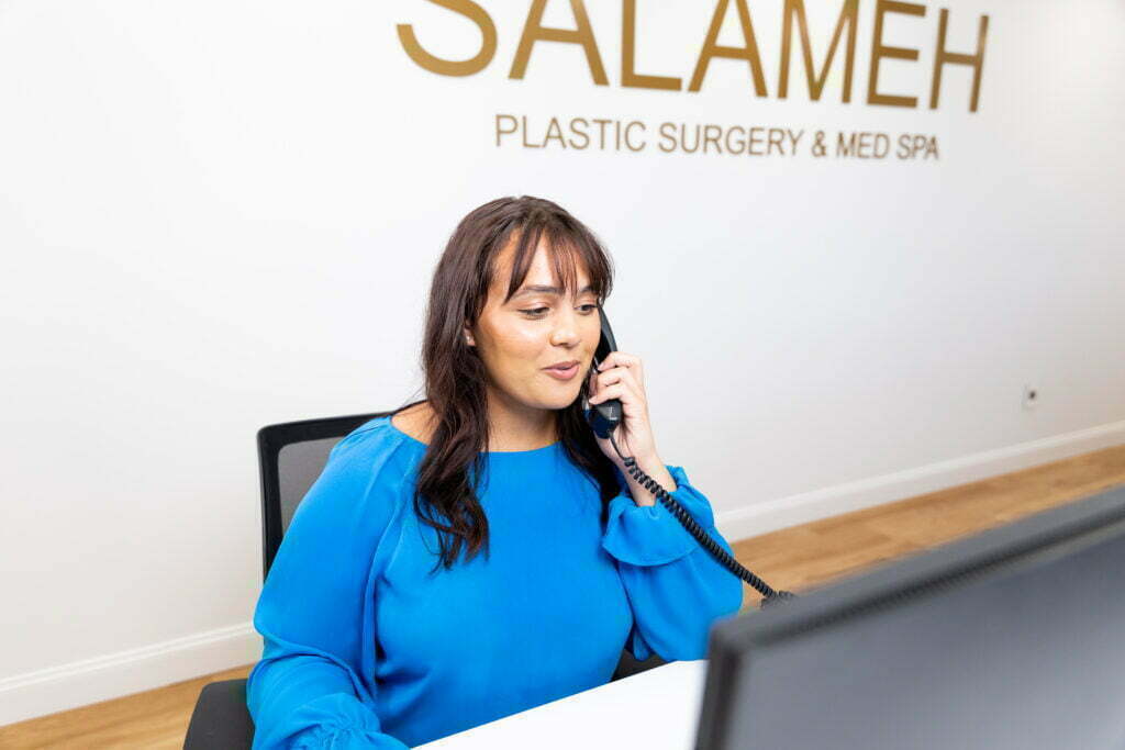 A Salameh Plastic Surgery Center staff at the front desk answering inquiry calls