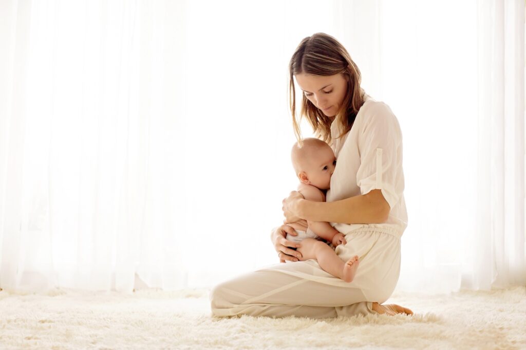 A new mom breastfeeding her child after breast reduction surgery