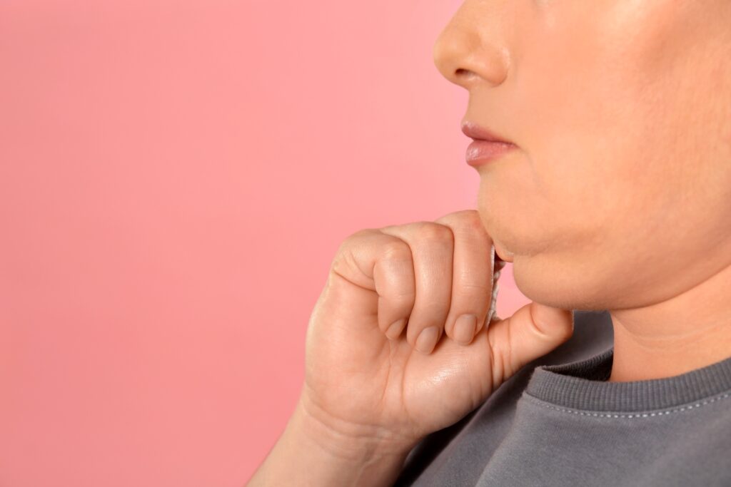 Woman with double chin on pink background, closeup. Space for text